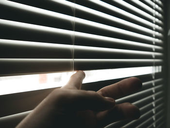 Hand is pushing closed blinds