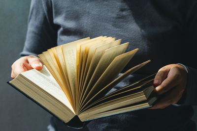 Midsection of person holding book