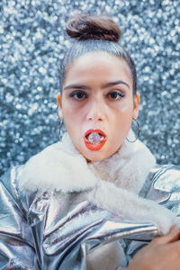 Portrait of woman with ice in mouth against defocused background