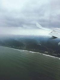 Cropped image of airplane flying over sea