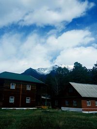 Houses on mountain against cloudy sky