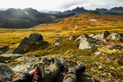 Low section of man sitting on mountain