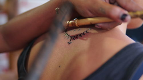 Cropped hands piercing on woman back