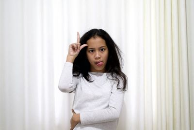 Portrait of girl standing against wall