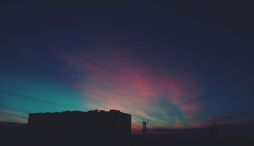 Silhouette buildings against sky during sunset