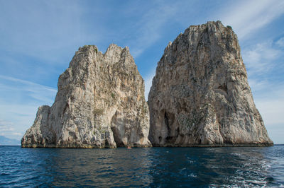 Rock formation in sea against sky