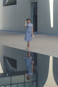 Full length rear view of woman standing in building
