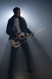 Portrait of young man playing guitar