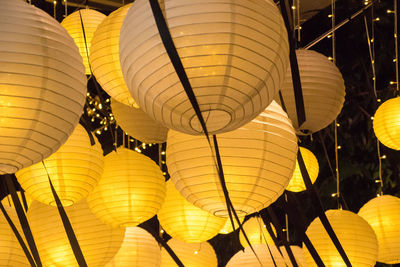 Low angle view of illuminated lanterns hanging at night