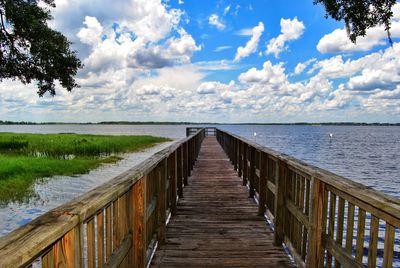 Wooden pier amidst sea against sky