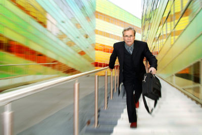 Portrait of businessman walking on steps