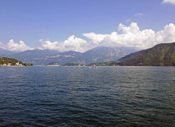 Scenic view of sea by mountains against sky