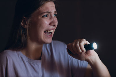 Portrait of young woman holding sparkler at home