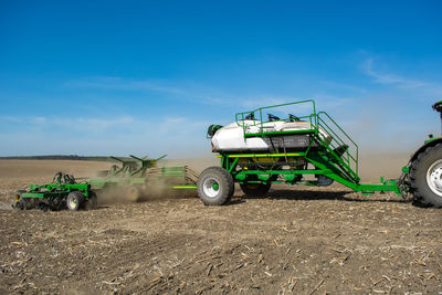 Tractor on agricultural field against sky