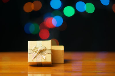 Close-up of gift on table against illuminated lights