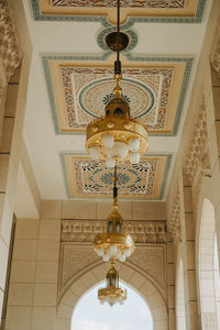 Low angle view of illuminated chandelier hanging in building