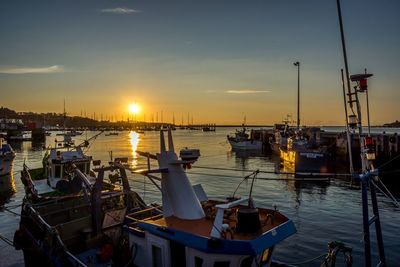 Boats in sea at sunset