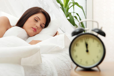 High angle view of woman sleeping on bed