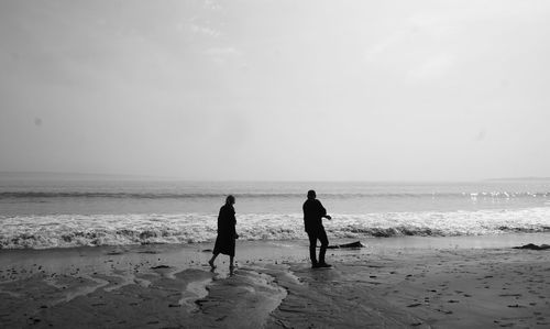 People at beach against sky