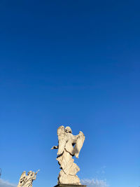 Low angle view of statue against blue sky