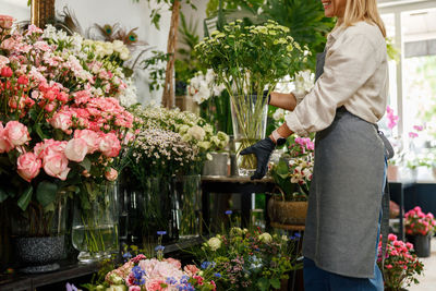 Midsection of woman holding flowers