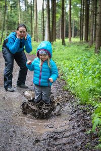 Full length of a boy and woman in forest