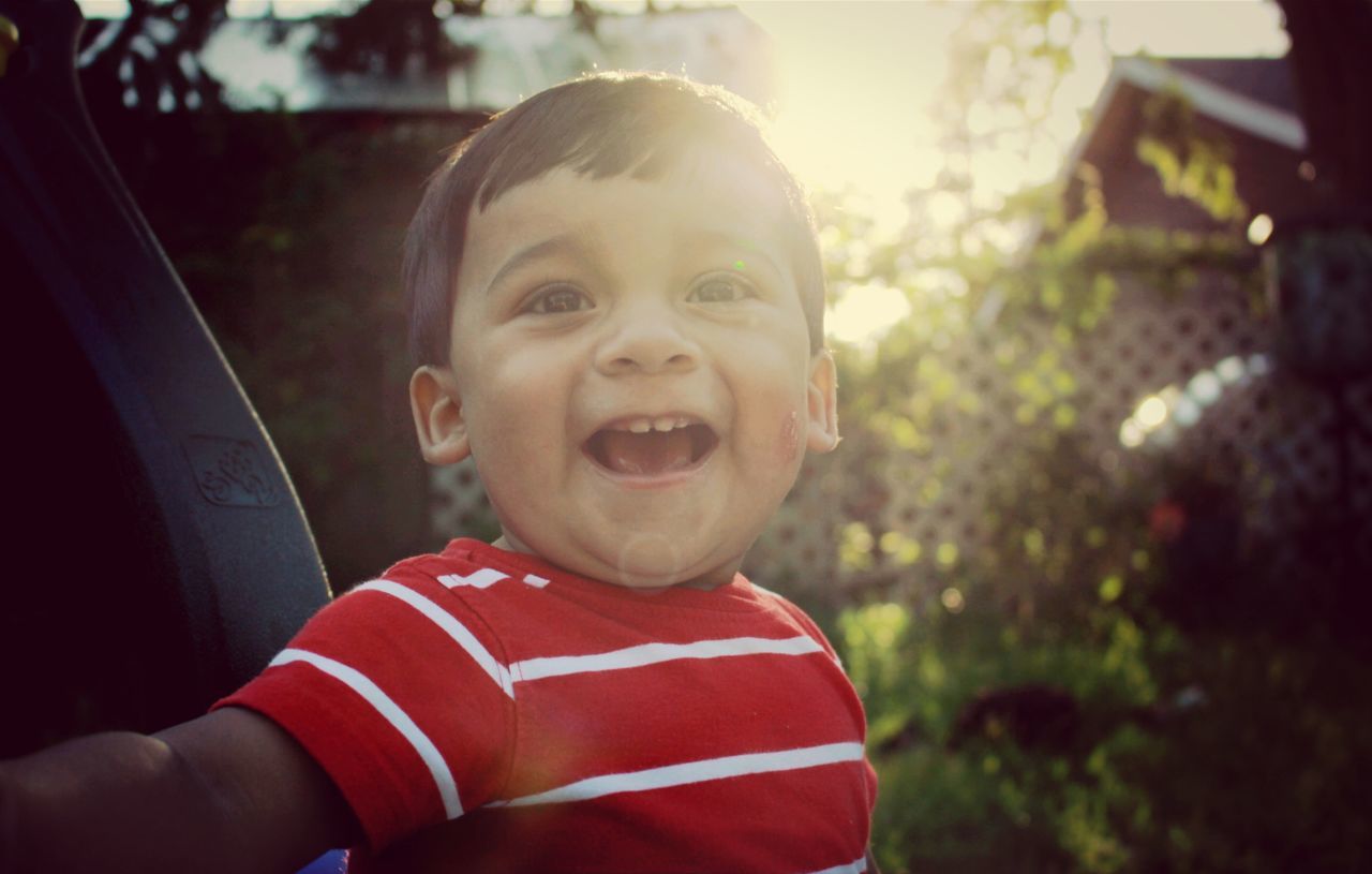 focus on foreground, lifestyles, person, portrait, looking at camera, leisure activity, casual clothing, front view, elementary age, headshot, smiling, childhood, boys, close-up, happiness, innocence, cute, holding