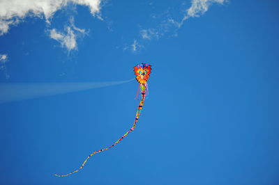 Low angle view of kite flying against blue sky