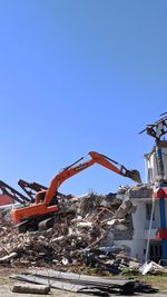 Cranes at construction site against clear blue sky