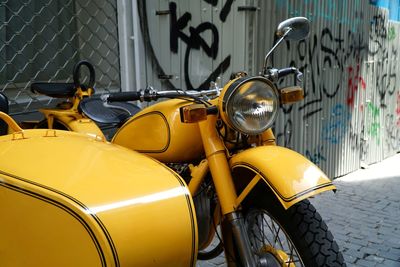 Close-up of yellow motorcycle on footpath