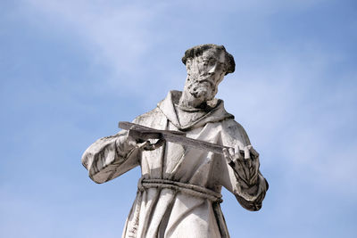 Low angle view of statue against blue sky