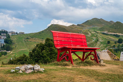 Red big bench in the alpine village of prato nevoso, piedmont