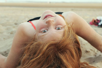 Close-up portrait of girl on sand at beach