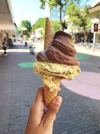 Close-up of hand holding ice cream cone on street