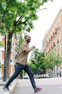 Positive afro american stylish man in european city