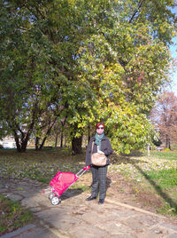 Portrait of young man standing against plants