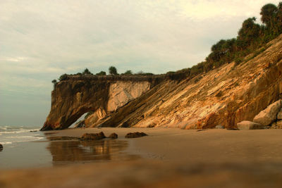 Scenic view of rocks on beach against sky