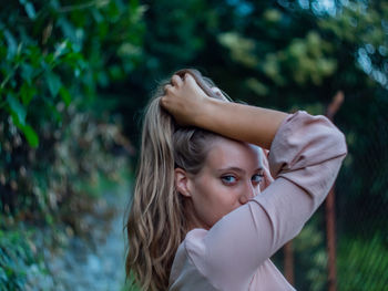 Portrait of woman standing against plants