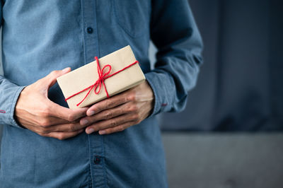 Midsection of man holding paper box