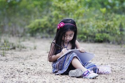 Portrait of young woman sitting on ground