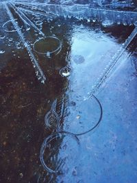High angle view of raindrops on puddle
