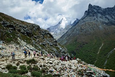 Group of people on mountain against sky