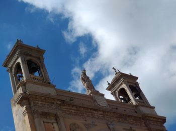 Low angle view of statue of historic building against sky