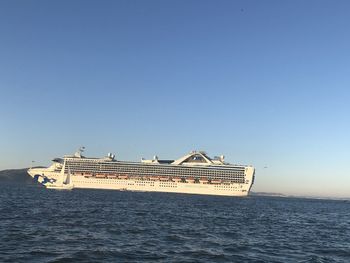 Ship sailing in sea against clear blue sky
