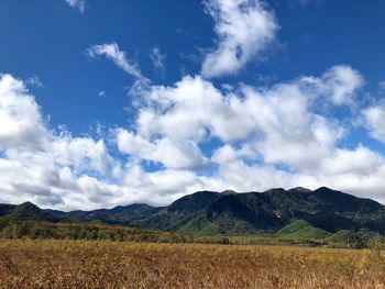 Scenic view of land and mountains against blue sky