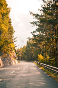 Diminishing perspective of empty road amidst trees against sky in forest