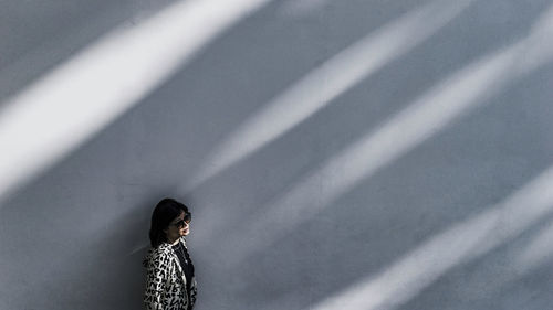 Midsection of woman standing against wall