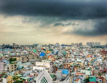 View of cityscape against cloudy sky