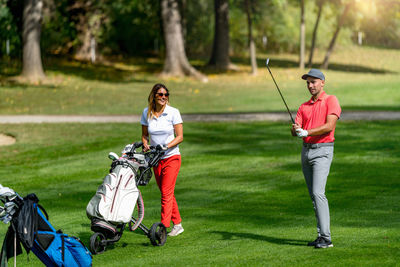 Young couple playing golf on a beautiful summer day