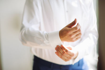 Midsection of man getting dressed in wedding